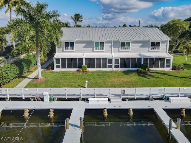 back of property with a sunroom and a yard