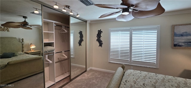 carpeted bedroom featuring ornamental molding, ceiling fan, and a closet