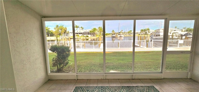 unfurnished sunroom featuring plenty of natural light and a water view