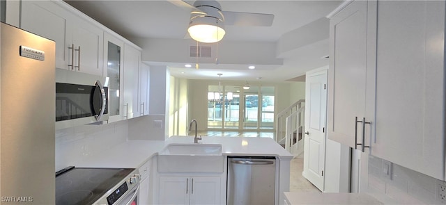 kitchen featuring white cabinetry, sink, appliances with stainless steel finishes, tasteful backsplash, and ceiling fan