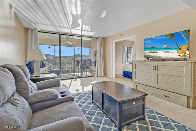 living area with carpet, floor to ceiling windows, ceiling fan, and baseboards