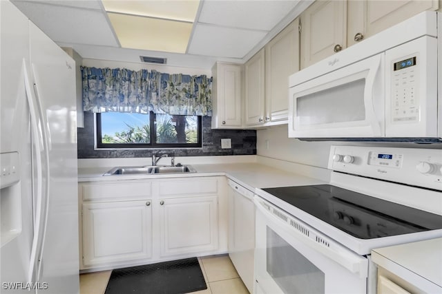 kitchen featuring white appliances, visible vents, light countertops, a paneled ceiling, and a sink