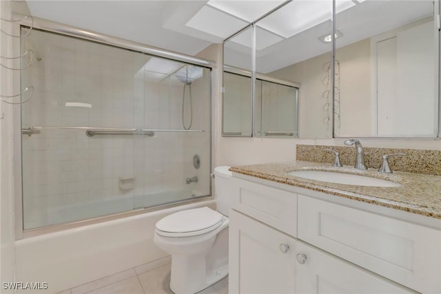 bathroom featuring toilet, shower / bath combination with glass door, tile patterned flooring, and vanity