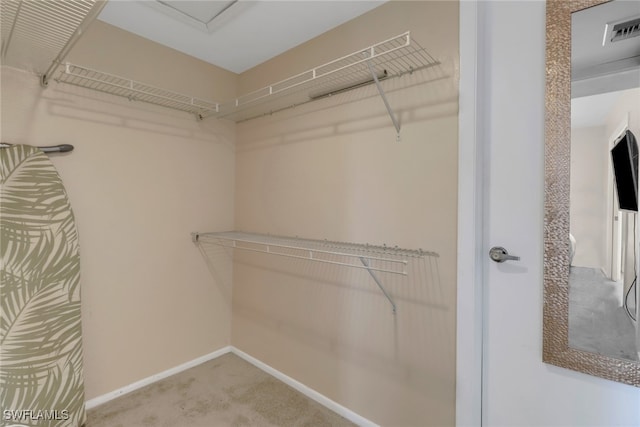 walk in closet featuring light colored carpet