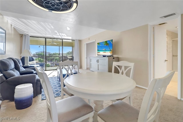 carpeted dining area featuring baseboards, visible vents, and a wall of windows