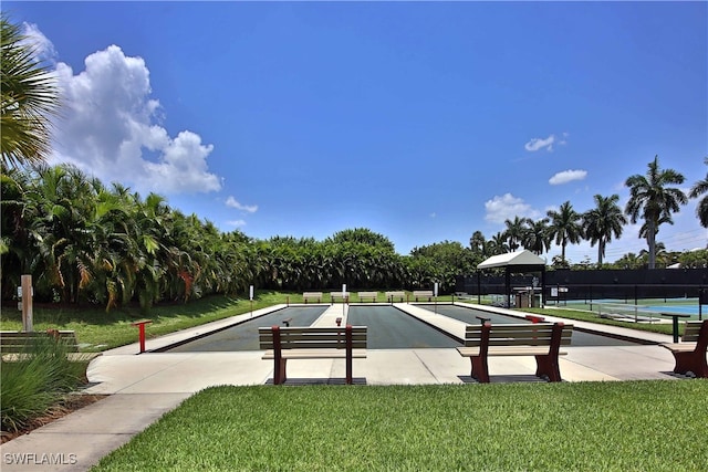 view of community with a lawn and fence