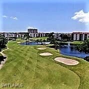 view of property's community with a water view and a lawn