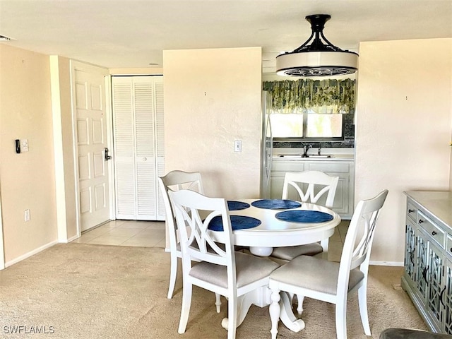 dining room featuring baseboards, light tile patterned flooring, and light colored carpet