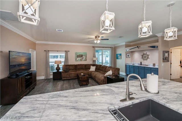 kitchen featuring crown molding, ceiling fan, sink, and light stone counters