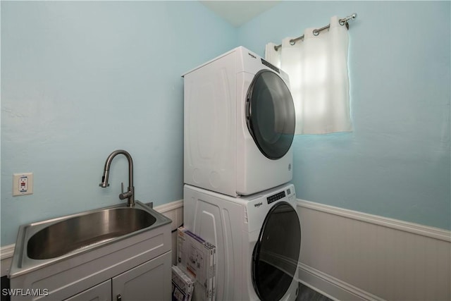 clothes washing area featuring stacked washer and dryer and sink