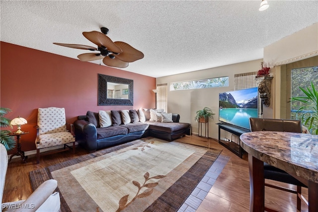 living room with a textured ceiling, hardwood / wood-style flooring, and ceiling fan