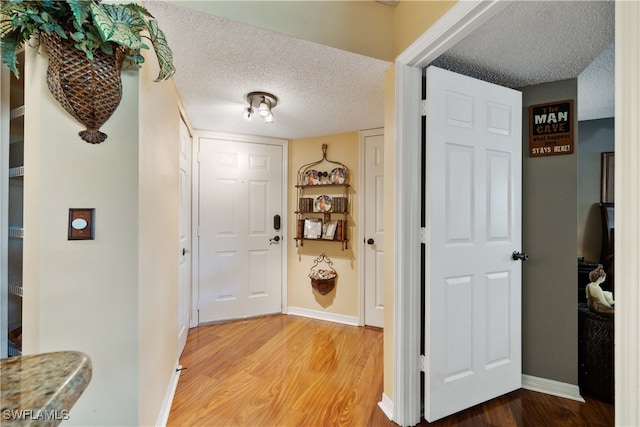 hall with a textured ceiling and hardwood / wood-style floors