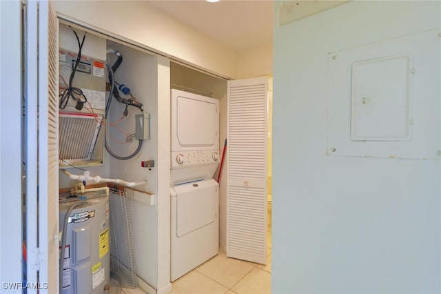 laundry room featuring water heater, electric panel, stacked washer / dryer, and light tile patterned floors