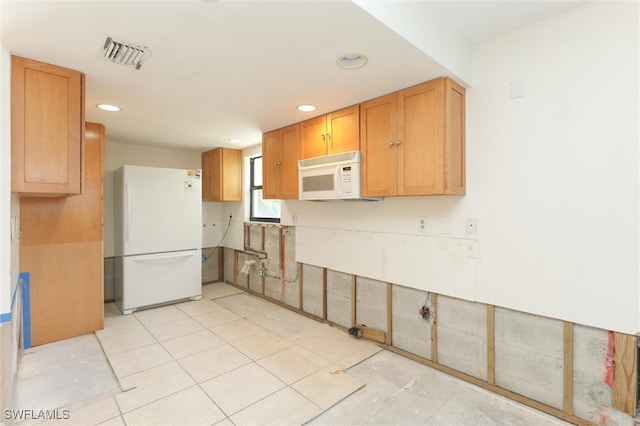 kitchen with white appliances and light tile patterned floors