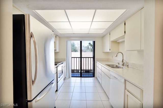 kitchen with light tile patterned flooring, white appliances, and sink