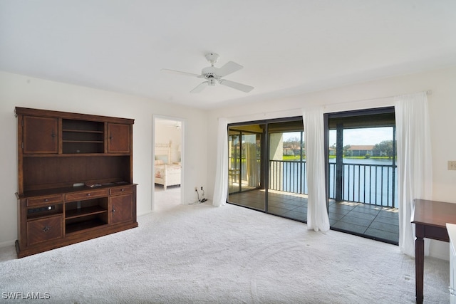 unfurnished bedroom featuring access to exterior, light carpet, and a water view