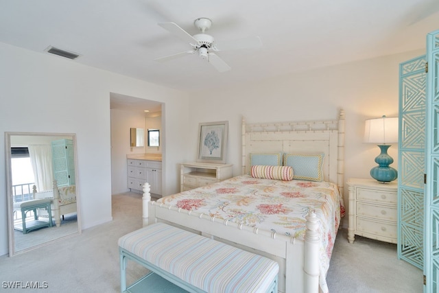 bedroom with light colored carpet, ensuite bath, and ceiling fan