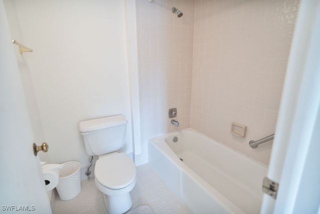 bathroom with tile patterned flooring, tiled shower / bath combo, and toilet