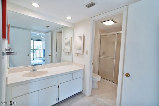 bathroom with ceiling fan, vanity, an enclosed shower, and toilet