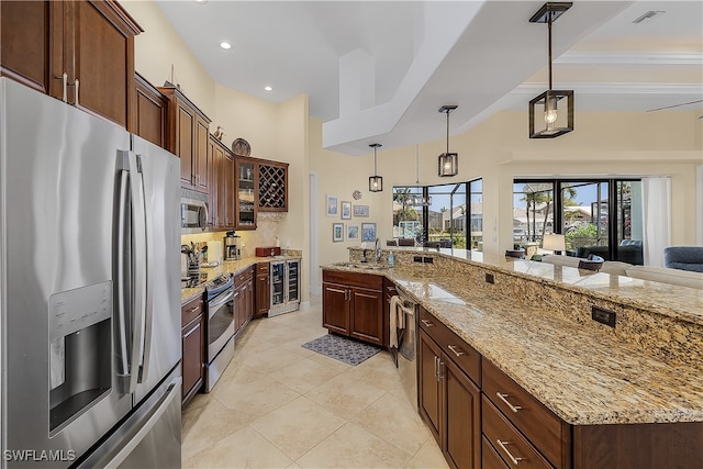 kitchen with stainless steel appliances, sink, light stone countertops, decorative light fixtures, and beverage cooler