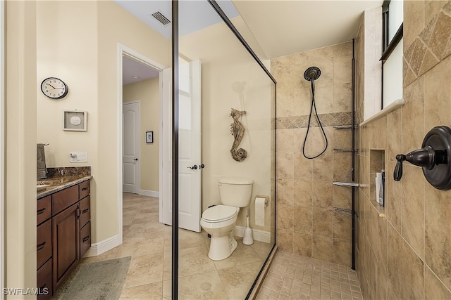 bathroom with vanity, toilet, and tiled shower