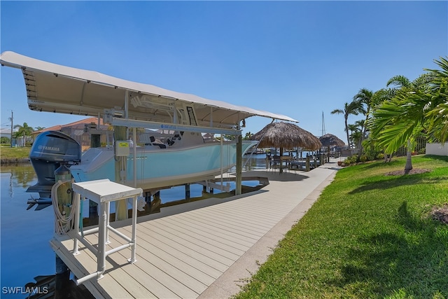 view of dock with a water view and a lawn