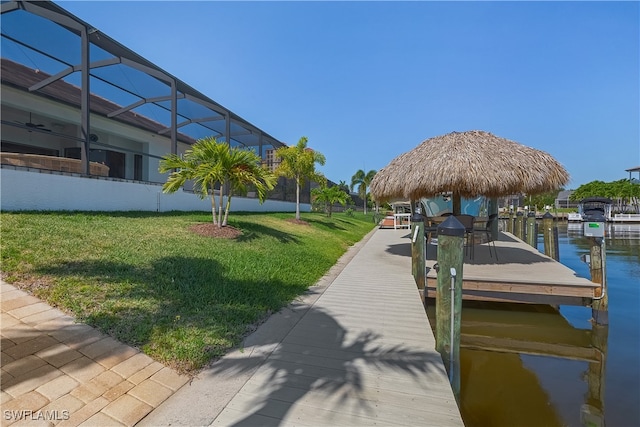 view of dock featuring a water view, a lanai, and a lawn