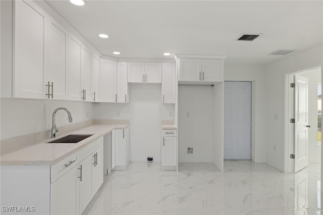 kitchen featuring sink and white cabinets