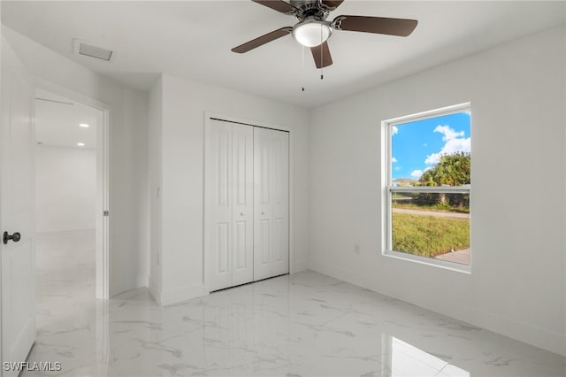 unfurnished bedroom with ceiling fan and a closet