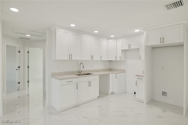 kitchen featuring white cabinetry and sink