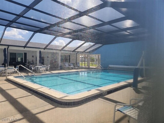 view of swimming pool with glass enclosure and a patio area