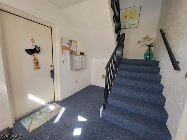 staircase featuring a textured wall