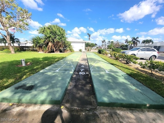 view of property's community featuring shuffleboard and a lawn