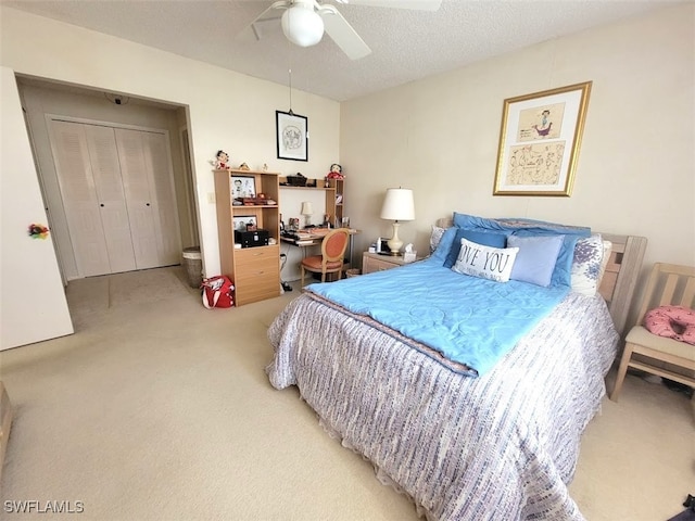 bedroom featuring carpet flooring, ceiling fan, a closet, and a textured ceiling