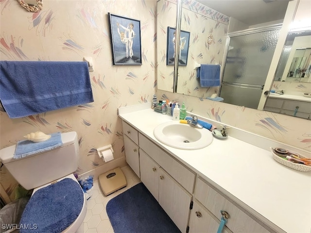 bathroom featuring tile patterned floors, a shower with door, vanity, and toilet