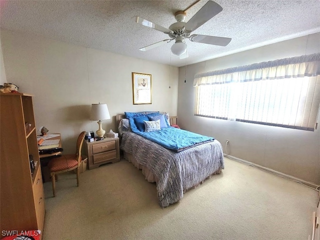 carpeted bedroom featuring ceiling fan and a textured ceiling