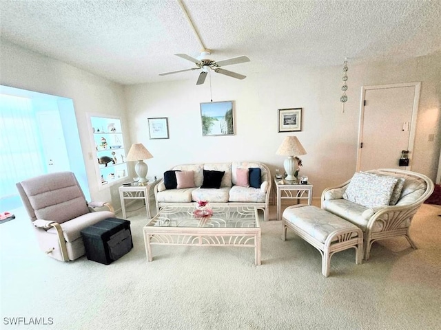 carpeted living room featuring built in shelves, ceiling fan, and a textured ceiling