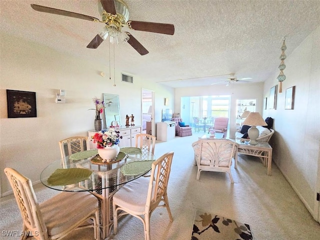 dining space featuring carpet floors, visible vents, and a textured ceiling