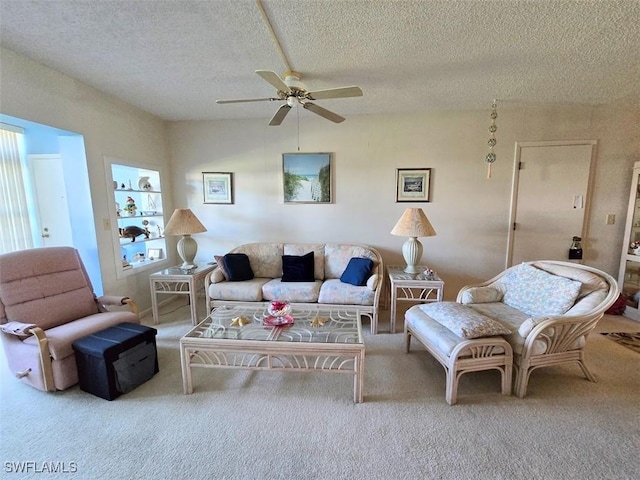 living area featuring a ceiling fan, light carpet, and a textured ceiling