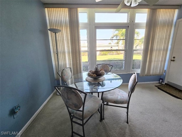 dining room featuring carpet floors, baseboards, and a ceiling fan