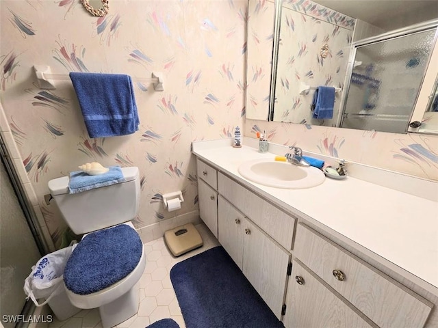 full bathroom with toilet, a stall shower, vanity, baseboards, and wallpapered walls