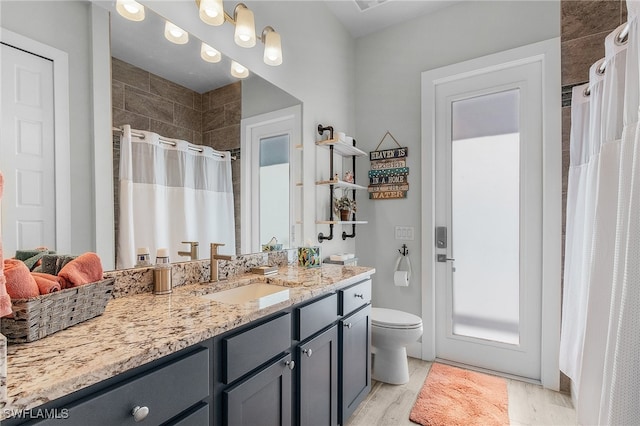 bathroom with vanity, curtained shower, toilet, and wood-type flooring