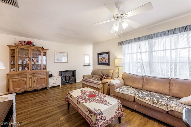 living room with ceiling fan and dark wood-type flooring