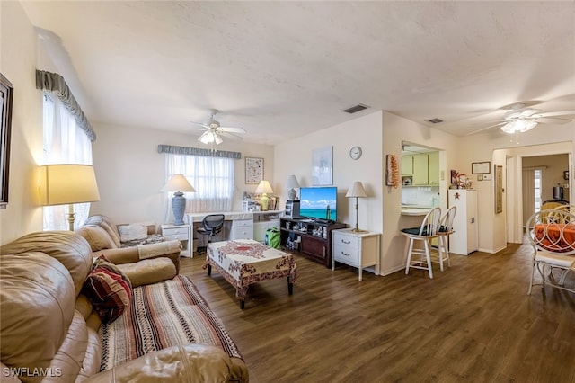 living room with dark hardwood / wood-style flooring and ceiling fan