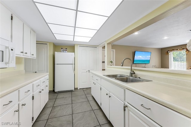 kitchen with white cabinetry, sink, and white appliances