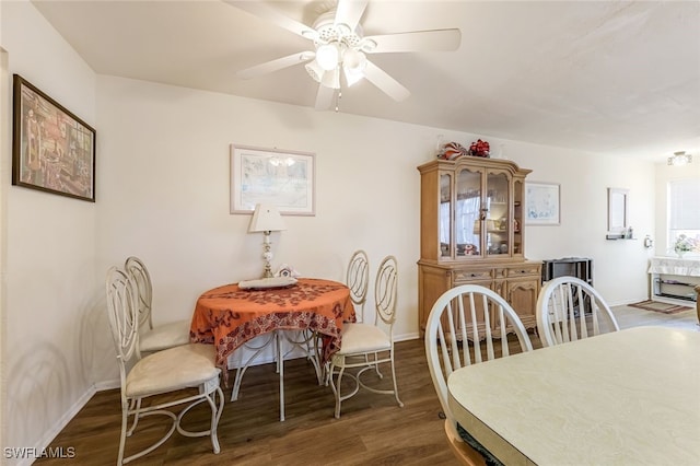 dining space with ceiling fan and dark wood-type flooring