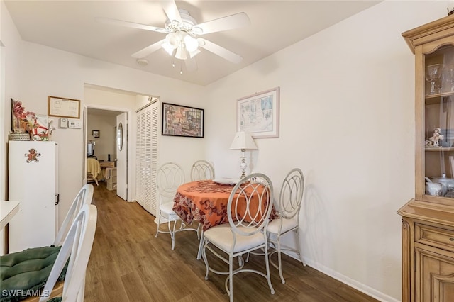 dining room with ceiling fan and dark hardwood / wood-style floors