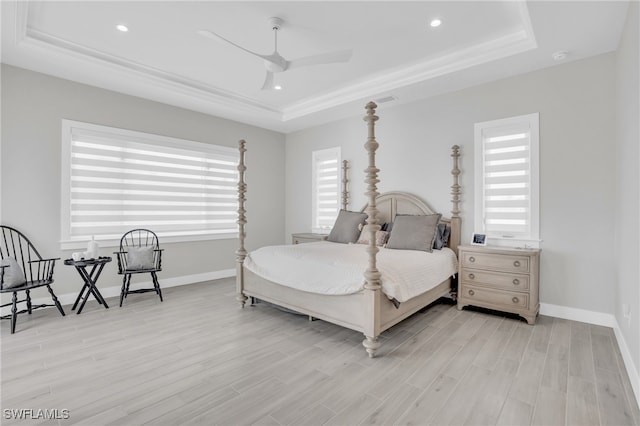 bedroom featuring ceiling fan, light wood-type flooring, and a raised ceiling