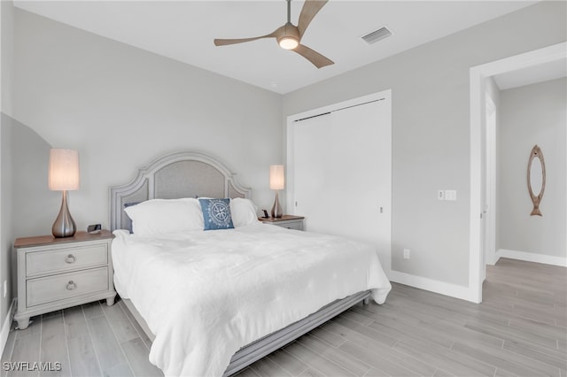 bedroom featuring light hardwood / wood-style flooring, a closet, and ceiling fan