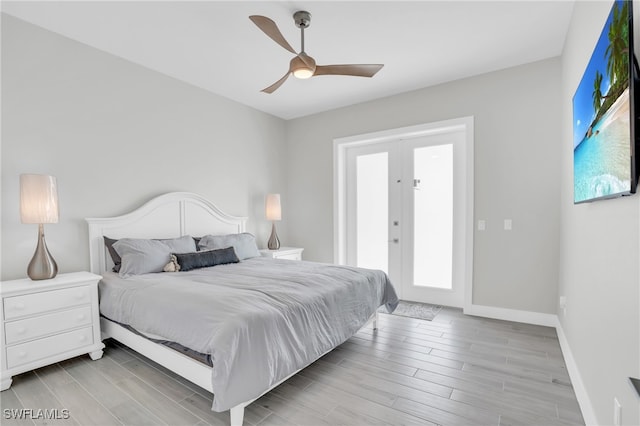 bedroom featuring french doors, light hardwood / wood-style flooring, multiple windows, and ceiling fan